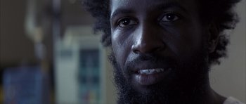 Movie still from “K-PAX” (2001), created by Robert Cochran – A man's face with a beard; Close Up shot, Low angle