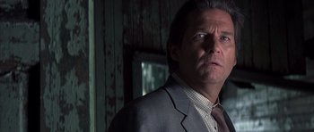 Movie still from “K-PAX” (2001), created by Robert Cochran – A person wearing a suit and tie; Close Up shot, Low angle