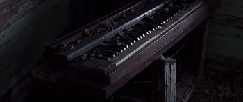 Movie still from “K-PAX” (2001), created by Robert Cochran – An old piano sitting inside of a building; Extreme Close Up shot, High angle