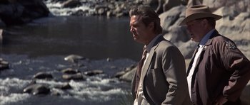 Movie still from “K-PAX” (2001), created by Robert Cochran – A man standing in front of a body of water; Medium shot, Low angle