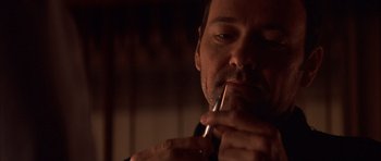 Movie still from “K-PAX” (2001), created by Robert Cochran – A person smoking a cigarette; Close Up shot, Low angle