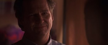 Movie still from “K-PAX” (2001), created by Robert Cochran – A man smiling for the camera; Close Up shot, Over the shoulder angle