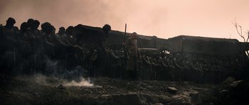 Movie still from “K.G.F: Chapter 2” (2022), directed by Prashanth Neel – A group of people standing around a fire; Wide shot, Low angle