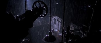 Movie still from “Kalifornia” (1993), directed by Dominic Sena – A man standing in the middle of a rain storm; Extreme Wide shot, High angle
