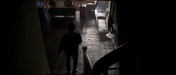Movie still from “Kalifornia” (1993), directed by Dominic Sena – A person walking down the stairs of a house; Wide shot, High angle