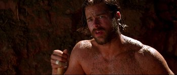 Movie still from “Kalifornia” (1993), directed by Dominic Sena – A man with long hair is holding a stick; Close Up shot, Over the shoulder angle