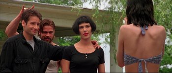 Movie still from “Kalifornia” (1993), directed by Dominic Sena – A woman that is wearing a black shirt; Medium shot, Low angle