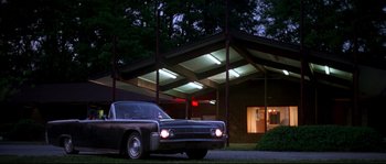 Movie still from “Kalifornia” (1993), directed by Dominic Sena – A car parked in front of a building at night; Extreme Wide shot, Low angle