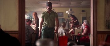 Movie still from “Kalifornia” (1993), directed by Dominic Sena – A group of people sitting at tables in a room; Medium shot, Low angle