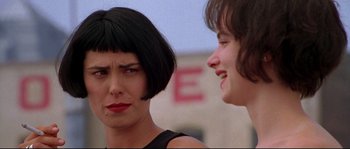 Movie still from “Kalifornia” (1993), directed by Dominic Sena – Two women talking to each other in front of a building; Close Up shot, Over the shoulder angle