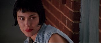 Movie still from “Kalifornia” (1993), directed by Dominic Sena – A person wearing a jean jacket near a brick wall; Close Up shot, Low angle