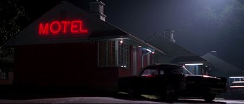 Movie still from “Kalifornia” (1993), directed by Dominic Sena – A car parked in front of a motel at night; Wide shot, Low angle