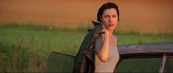 Movie still from “Kalifornia” (1993), directed by Dominic Sena – A woman holding a jacket over her head; Close Up shot, Low angle