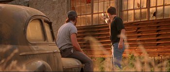 Movie still from “Kalifornia” (1993), directed by Dominic Sena – Two men sitting on the hood of a truck; Medium shot, Over the shoulder angle