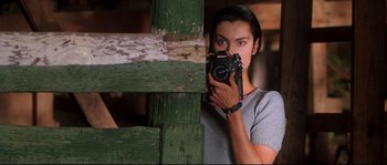 Movie still from “Kalifornia” (1993), directed by Dominic Sena – A woman taking a picture of herself with a camera; Close Up shot, Low angle