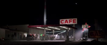 Movie still from “Kalifornia” (1993), directed by Dominic Sena – An old gas station at night with a cafe sign on the side; Extreme Wide shot, Low angle
