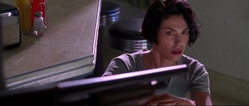 Movie still from “Kalifornia” (1993), directed by Dominic Sena – A woman sitting in front of a computer monitor; Close Up shot, Low angle
