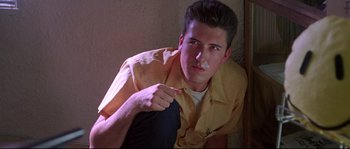Movie still from “Kalifornia” (1993), directed by Dominic Sena – A man in a yellow shirt is pointing to his face; Close Up shot, Low angle