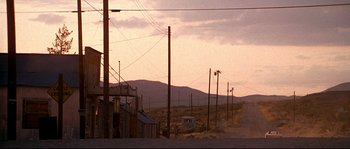 Movie still from “Kalifornia” (1993), directed by Dominic Sena – An empty road with power lines in the background; Extreme Wide shot, Low angle