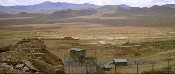 Movie still from “Kalifornia” (1993), directed by Dominic Sena – An open field with mountains in the background; Extreme Wide shot, High angle