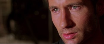 Movie still from “Kalifornia” (1993), directed by Dominic Sena – A man's face with green eyes; Extreme Close Up shot, Low angle