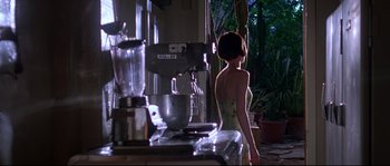 Movie still from “Kalifornia” (1993), directed by Dominic Sena – A woman standing in front of a blender in a kitchen; Medium shot, Low angle