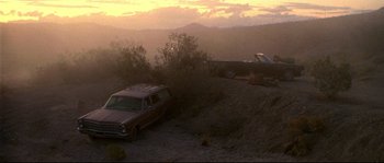 Movie still from “Kalifornia” (1993), directed by Dominic Sena – A couple of cars parked on top of a dirt hill; Extreme Wide shot, High angle