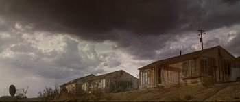 Movie still from “Kalifornia” (1993), directed by Dominic Sena – An old house is under a cloudy sky; Extreme Wide shot, Low angle