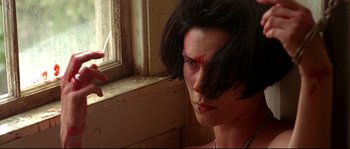 Movie still from “Kalifornia” (1993), directed by Dominic Sena – A woman with a knife in her hand and blood on her face; Close Up shot, Low angle