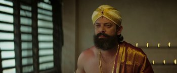 Movie still from “Kantara” (2022), directed by Rishab Shetty – A man with a beard wearing a turban; Close Up shot, Low angle