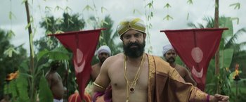 Movie still from “Kantara” (2022), directed by Rishab Shetty – A man with a beard and a yellow turban; Medium shot, Low angle