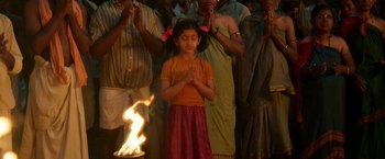 Movie still from “Kantara” (2022), directed by Rishab Shetty – A group of people standing in front of a fire; Medium shot, High angle