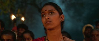 Movie still from “Kantara” (2022), directed by Rishab Shetty – A young woman with a necklace on her head; Close Up shot, Low angle