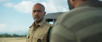 Movie still from “Kantara” (2022), directed by Rishab Shetty – A person wearing a uniform; Close Up shot, Low angle