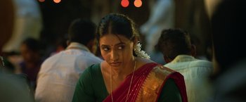 Movie still from “Kantara” (2022), directed by Rishab Shetty – A person wearing a green shirt; Close Up shot, Over the shoulder angle
