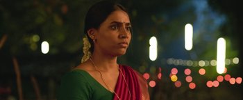 Movie still from “Kantara” (2022), directed by Rishab Shetty – A woman in a green and red sari looking into the distance; Close Up shot, Low angle