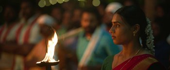 Movie still from “Kantara” (2022), directed by Rishab Shetty – A woman standing in front of a lit candle; Close Up shot, Over the shoulder angle
