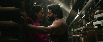 Movie still from “Kantara” (2022), directed by Rishab Shetty – A man and a woman are holding each other close; Close Up shot, Low angle