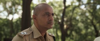 Movie still from “Kantara” (2022), directed by Rishab Shetty – A person wearing a military uniform; Close Up shot, Low angle