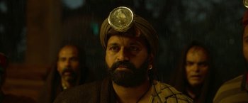Movie still from “Kantara” (2022), directed by Rishab Shetty – A man with a beard and a turban on his head; Close Up shot, Low angle