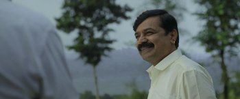Movie still from “Kantara” (2022), directed by Rishab Shetty – A person wearing a white shirt; Close Up shot, Low angle