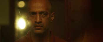 Movie still from “Kantara” (2022), directed by Rishab Shetty – A man with a bald head is looking at the camera; Close Up shot, Low angle