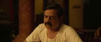 Movie still from “Kantara” (2022), directed by Rishab Shetty – A person with a beard and mustache; Close Up shot, Over the shoulder angle