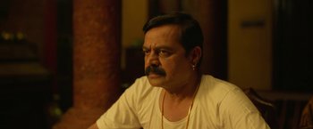 Movie still from “Kantara” (2022), directed by Rishab Shetty – A person with a beard and mustache; Close Up shot, Over the shoulder angle