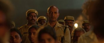 Movie still from “Kantara” (2022), directed by Rishab Shetty – A group of men in uniform standing in a line; Close Up shot, Over the shoulder angle