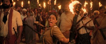 Movie still from “Kantara” (2022), directed by Rishab Shetty – A group of people in the street with torches; Medium shot, High angle