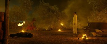 Movie still from “Kantara” (2022), directed by Rishab Shetty – Two men are standing in front of a fire; Extreme Wide shot, High angle