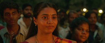 Movie still from “Kantara” (2022), directed by Rishab Shetty – A person wearing a yellow and red shirt; Close Up shot, Over the shoulder angle