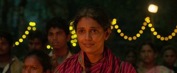 Movie still from “Kantara” (2022), directed by Rishab Shetty – A woman in a red and yellow striped shirt; Close Up shot, Low angle
