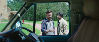 Two men standing next to each other on a road